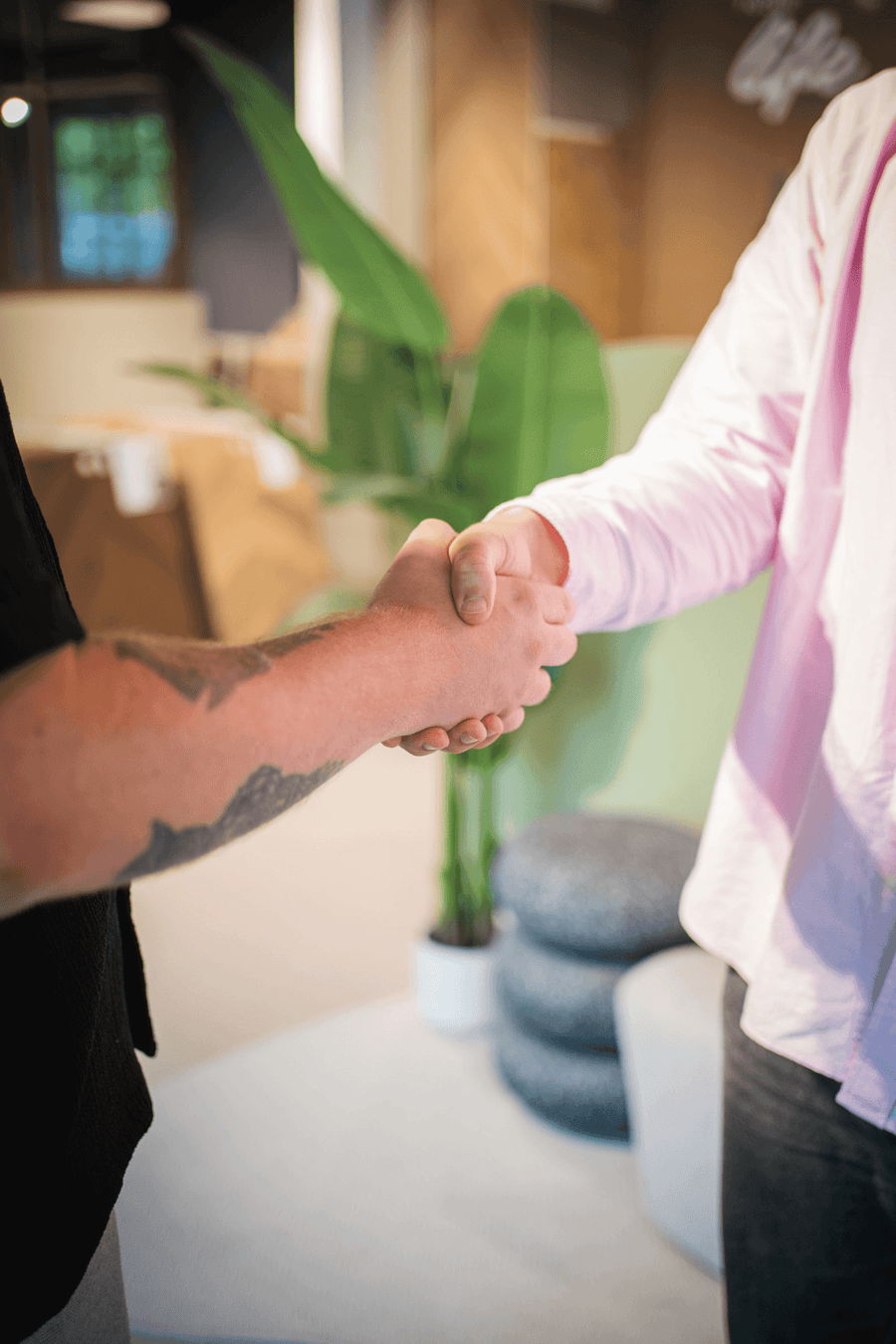 Handdruk tussen een medewerker en een klant in de showroom van Solza