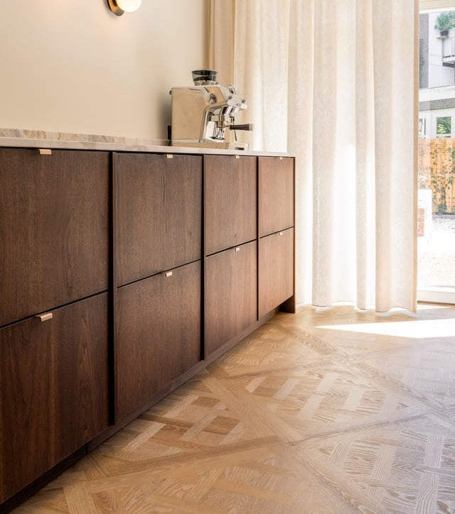 Cuisine avec des façades en placage foncé, une machine à espresso et un parquet Versailles